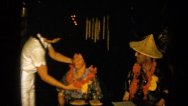 1961: Woman Accepting Flower Necklace in Tropical Celebration, California