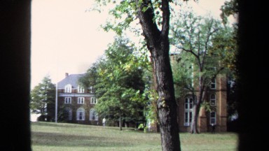 1970: Number of People Moving in Large Field Near Building in Annapolis