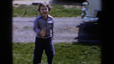1959: A Young Short-Haired Girl Running Toward the Camera in Her Yard