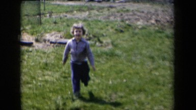 1959: Small Child Running to Camera and Petting Dog New York