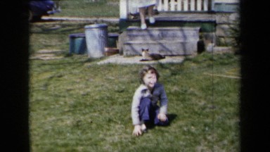 1959: Mom Petting Cat and Boy Pulling Grass in New York