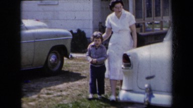 1959: A Mother and Her Son Walking Past a White Car in New York