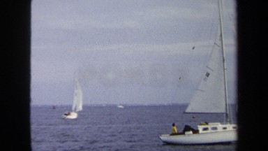 1970: Sailboat on Choppy Water with Multiple Sailboats in Background