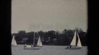 1970: dozens of sailboats on the water and older kids playing a game of football