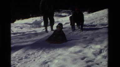 1981: A Boy Getting a Push Down a Snowy Slope on a Sled in California