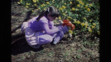 1985: A Girl and Her Rag Doll Smelling Flowers at Daffodil Hill California