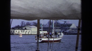 1970: Large Sailing Vessel in Foreground with Bay and Boats in Background