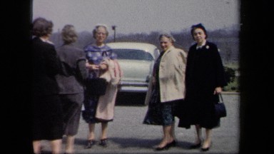 1958: Six Women Dressed Elegantly Standing in a Parking Lot