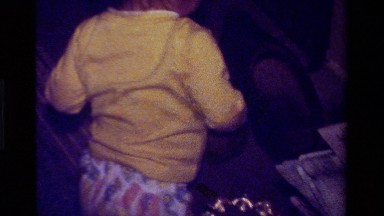 1979: A Small Kid in Yellow Dress Picking Up a Ball from a Bag