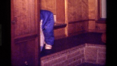 1979: Child Wearing Denim Overalls Crawling Near Doorway in California