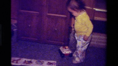 1979: Child Pulling Toy Inside Furnished Living Room in California