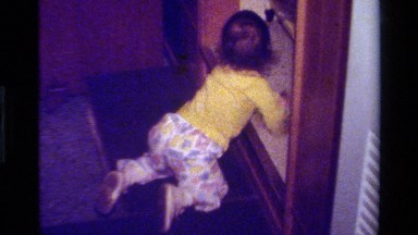 1979: Camera Pans In On Little Girl Walking In California Living Room