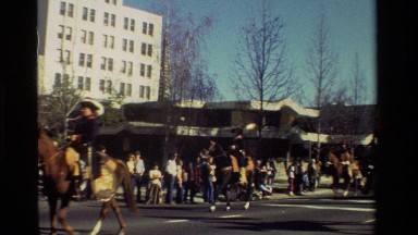 1981: man rides through parade on back of horse. CALIFORNIA