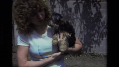 1979: A Young Woman Holding a Small Dog as It Kisses Her Face
