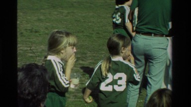 1981: a man in sunglasses takes pictures of children playing sports CALIFORNIA