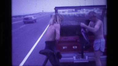 1977: People Getting Dressed in Car at Laguna Beach California
