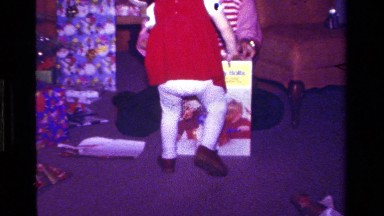 1979: child opens christmas present from family CALIFORNIA