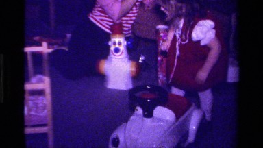1979: a small girl in red dress playing with many toys inside the room