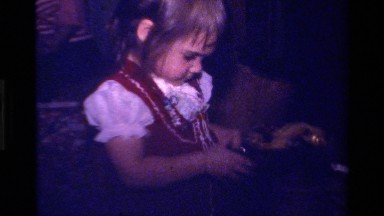 1979: a cute and beautiful baby opening the gift with happiness and curiosity