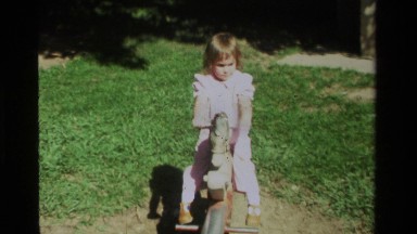 1979: a small baby girl playing with her toy horse in the garden area CALIFORNIA