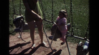 1979: young girl is helped by mother in having fun on the swing set CALIFORNIA