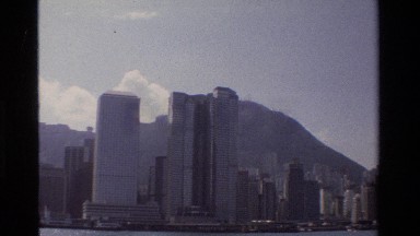 1984: Geometric Urban Skyline of Towers and Skyscrapers Stands Between Mountain