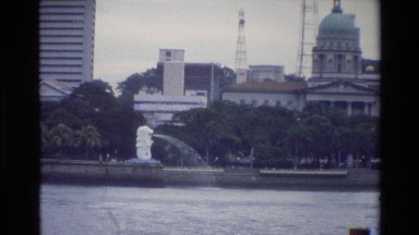 1984: A Boat Moving Along the River in Singapore with Urban Buildings