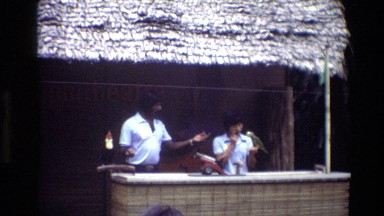 1984: Two People Performing Bird Tricks with Toucan and Parrot for Tourists in Singapore