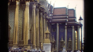1984: a stone buddha statue rests in front of a decorated building THAILAND