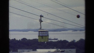 1984: ropeway passenger cabin moving away from the ropeway tower through cables.
