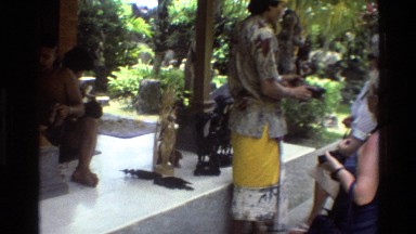 1984: A Person in Yellow Dress Showing Statue to Others in Cambodia