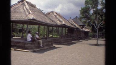 1984: two people relaxing in shade of huts in southeast asia SINGAPORE