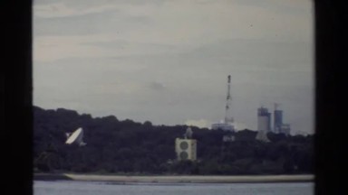 1984: Near a Narrow Beach, Observers on a Small Boat Look Inland