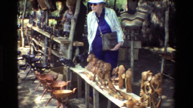 1983: a lady holds her large handbag close to her chest in a market NAIROBI