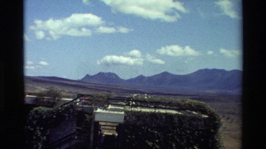 1983: a building covered in green vines and moss sits in a rural area KILAGUNI