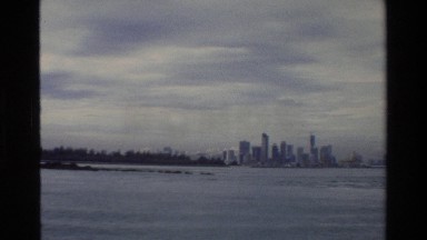 1984: View of Singapore Island with Large Buildings and Many Boats Sailing