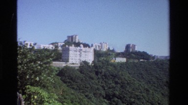 1984: a city skyline runs along the ridge of a heavily forested mountain side
