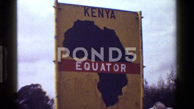 1983: Group of People Walking in Grassland Near Small Hut in Kenya