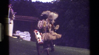 1983: many people wearing costumes while dancing around in a grassy area KENYA