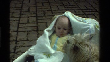 1975: A Dog Sniffing a Grumpy Baby in California