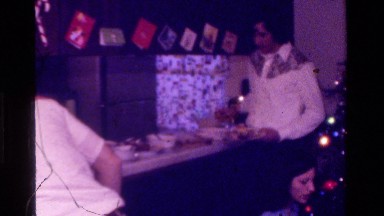 1975: teenage brothers and sisters take their plates to the meal table at