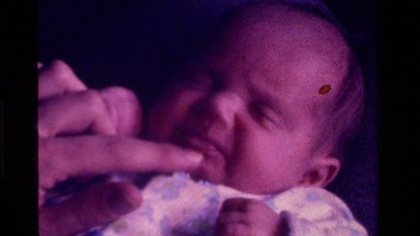 1975: a small kid is in deep sleep and mother trying to wake it up CALIFORNIA