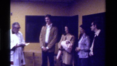 1975: new parents standing with their baby, and two friends, getting the baby