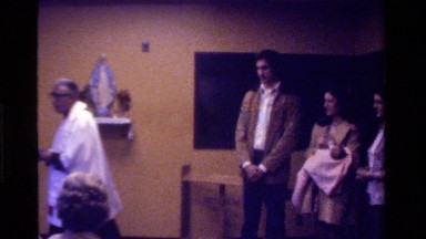 1975: a women carrying a baby is talking to father in church CALIFORNIA