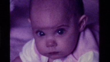 1975: a baby on tummy time trying to roll over CALIFORNIA