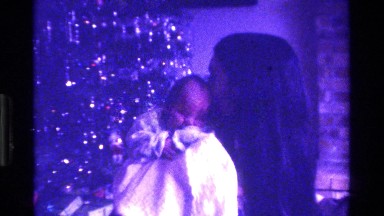 1975: woman cuddling newborn with christmas tree in the background CALIFORNIA
