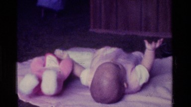 1975: a baby laying down kicking CALIFORNIA