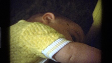 1975: a wee little baby crawling around on a bed CALIFORNIA