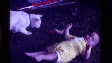 1975: toddle lying down pet walking along CALIFORNIA