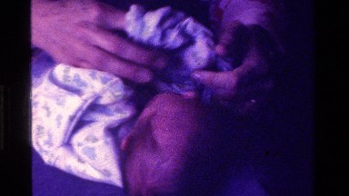 1975: young infant being dressed CALIFORNIA